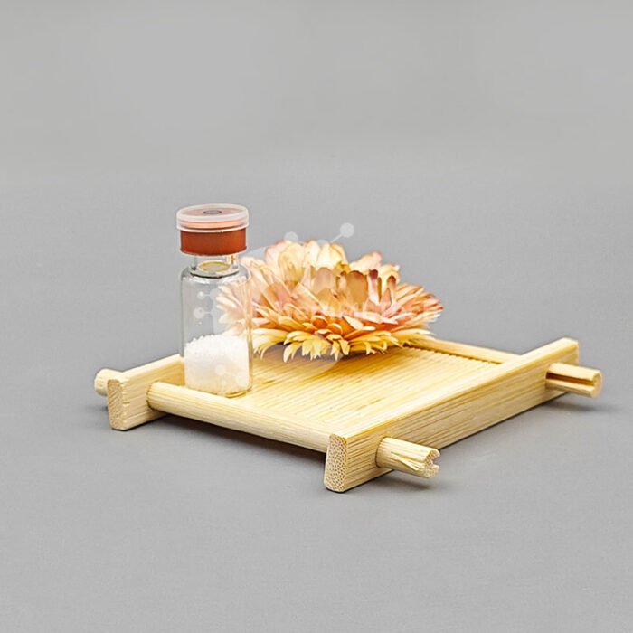 Glass vial of Soy Peptide powder placed on a bamboo tray with decorative dried flowers, showcasing clean-label plant-based skincare ingredient