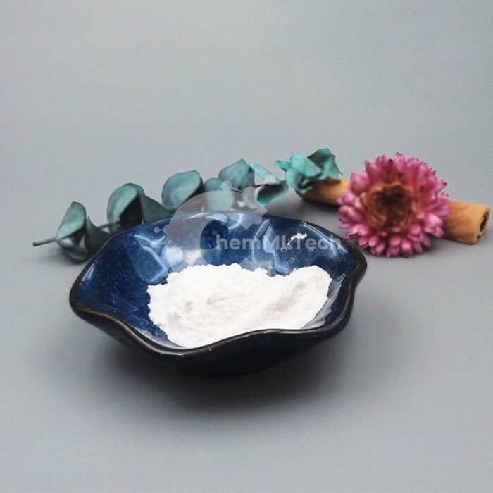 White Resveratrol powder displayed in a dark ceramic bowl, with decorative flower and cinnamon, used in anti-aging and brightening skincare