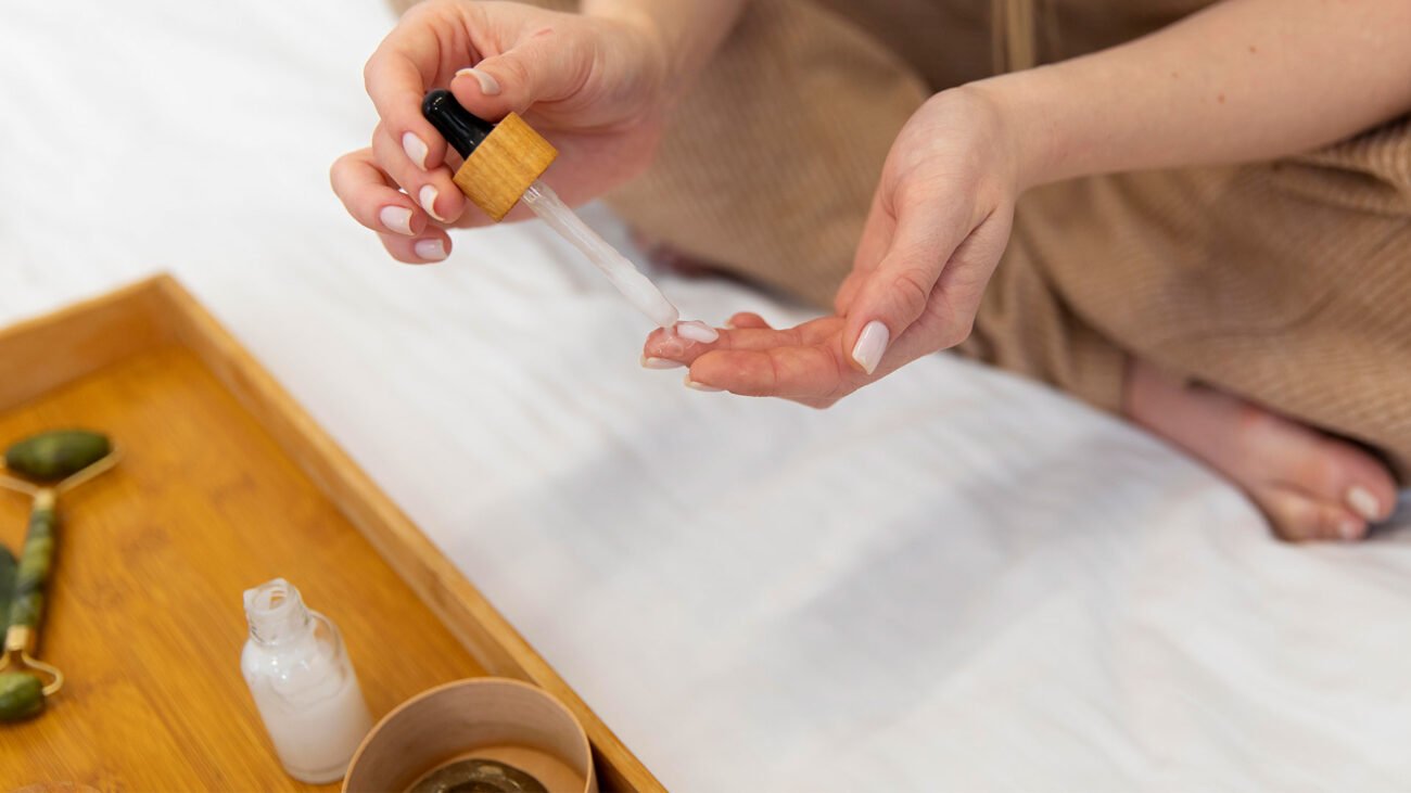A woman applying NAD+ peptide serum with a dropper on her hand, highlighting skincare benefits and anti-aging effects.