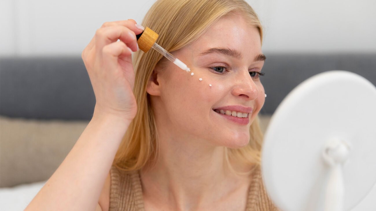 Young woman applying Snap 8 Peptide serum to her face for wrinkle reduction and smoother skin