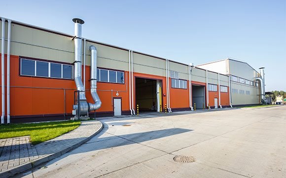 Chemmltech Modern Chemical Manufacturing Facility Exterior Exterior view of Chemmltech's chemical manufacturing plant with advanced ventilation system and loading areas
